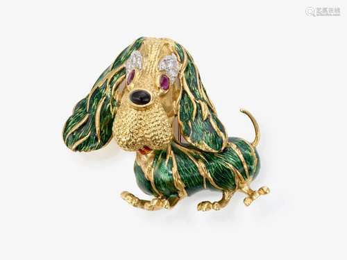 A brooch in the shape of a basset with green enamel, rubies,...