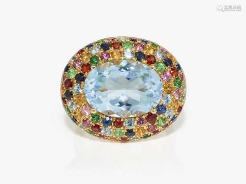 A cocktail ring decorated with a large topaz and multi-colou...