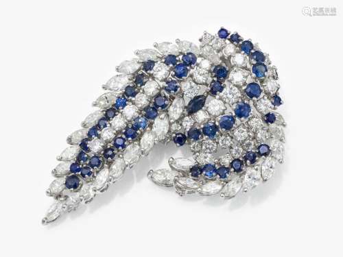 A brooch in the shape of a cascade of leaves with sapphires ...
