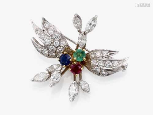 A stylised floral brooch decorated with diamonds, emerald, r...