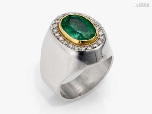 A entourage-set ring decorated with a large emerald and bril...