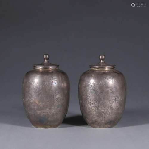 A pair of flower and butterfly patterned silver jars