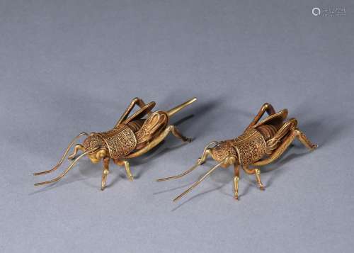 A pair of gold grasshoppers