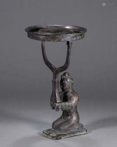 A copper candlestick with kneeling figure pedestal