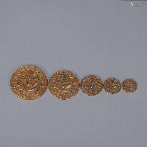 A set of 5 dragon patterned gold coins