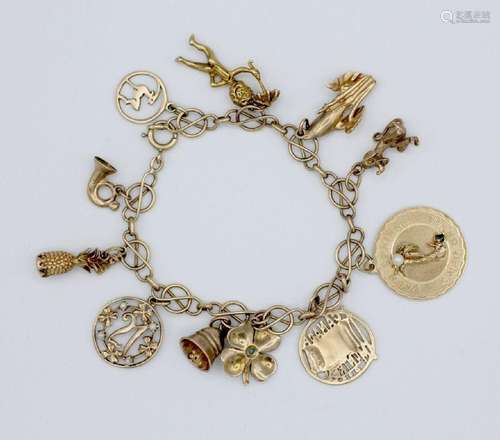 A 10kt yellow gold charm bracelet with assorted charms.