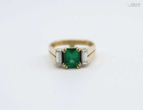 A lady’s 18kt yellow gold, emerald, and diamond ring