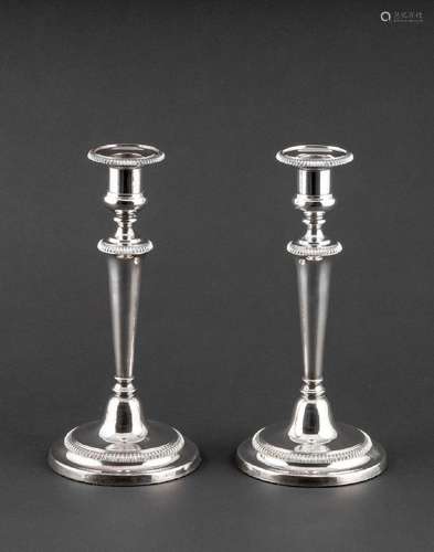 A pair of electroplated silver candlesticks of tapered colum...