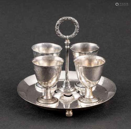 A sterling silver egg cruet, the circular tray fitted with f...