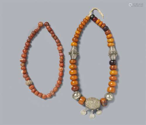 Two Tibetan amber and other resins, silver, and coral beads ...