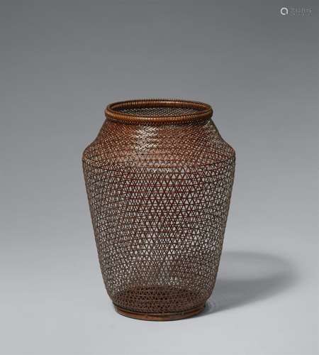 A small woven bamboo and rattan ikebana basket by Maeda Chik...