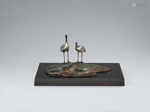 A bronze okimono of cranes by a shore. 20th century