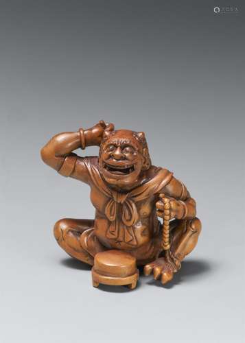 A large boxwood okimono netsuke of a laughing oni. Late 19th...