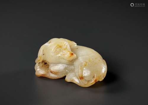 A PALE CELADON AND RUSSET JADE FIGURE OF A DOG, 17TH-18TH CE...