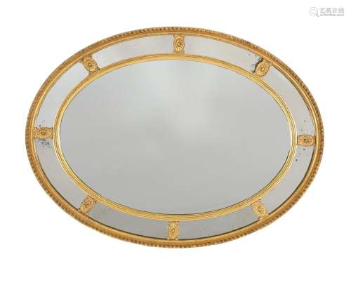 A GILTWOOD AND COMPOSITION OVAL WALL MIRROR IN GEORGE III ST...
