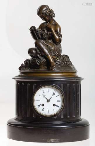 Clock with a black marble base and topped with a blued bronz...