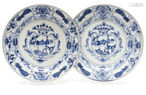 A pair of blue and white plates with peacocks in the border