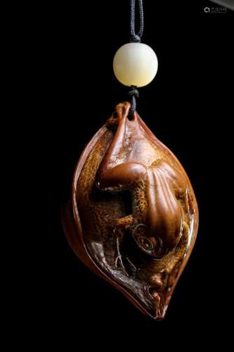 A carved tree frog fan pendant with an olive pit from the Qi...