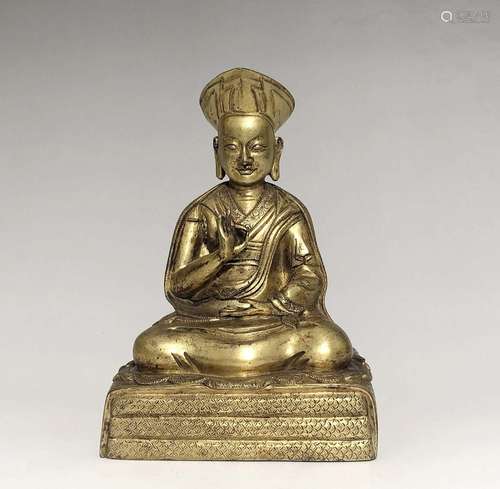 A GILT-BRONZE FIGURE OF GURU.QING