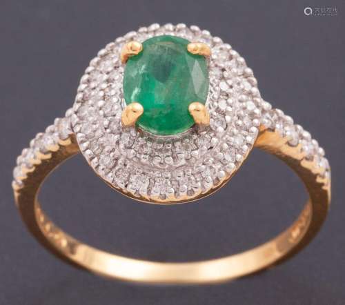 RING WITH CENTRAL EMERALD SURROUNDED BY A BORDER OF DIAMONDS...
