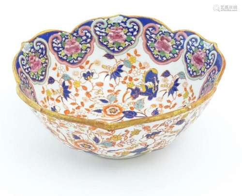 A Chinese bowl with a scalloped edge decorated with scrollin...