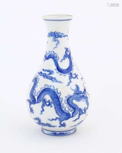 A Chinese blue and white vase decorated with three dragons a...