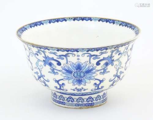 A Chinese blue and white bowl decorated with scrolling flora...