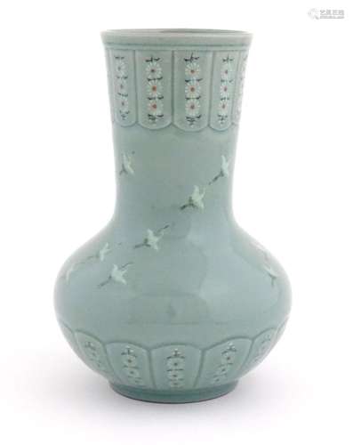 An Oriental celadon glazed vase decorated with crane birds a...