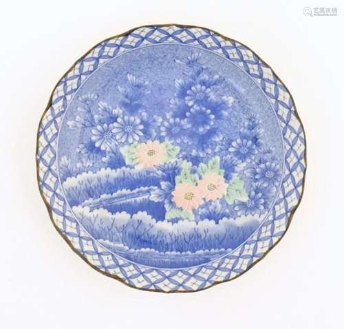 An Oriental blue and white plate with pink and green highlig...