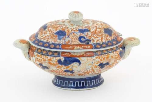 A sauce tureen and cover with twin handles decorated in the ...