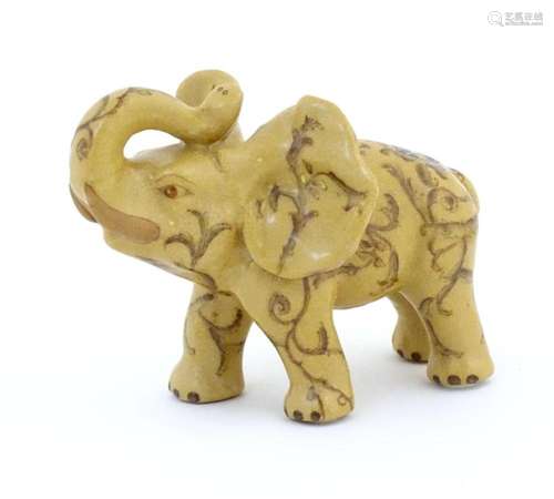 An Oriental ceramic model of an elephant with painted detail...