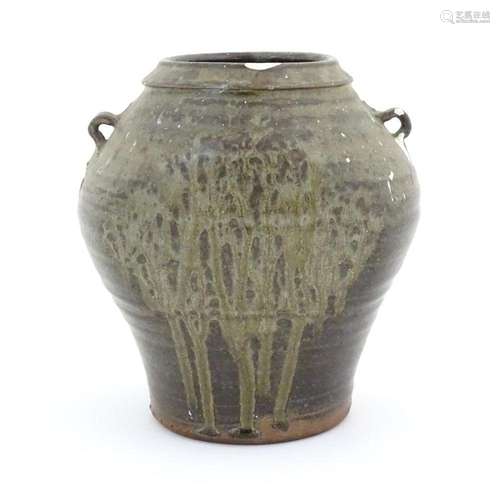 A studio pottery vase with twin loop handles and drip glaze....