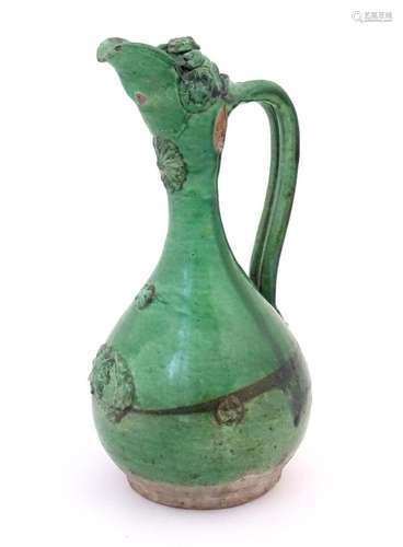 A Turkish Canakkale pottery jug / ewer with a green glaze. A...