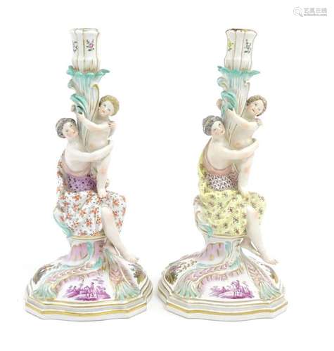 A pair of Continental porcelain figural candlesticks on shap...