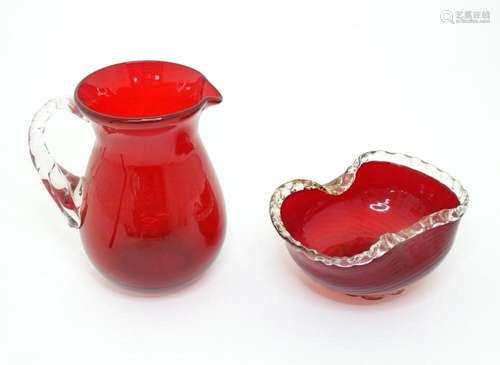 Two items of glassware comprising a red glass water jug with...