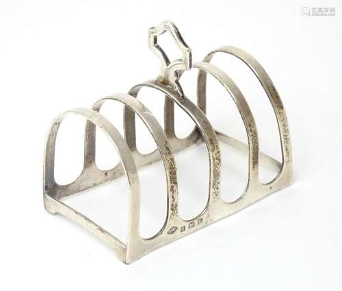 A silver five bar toast rack hallmarked Birmingham 1929, mak...