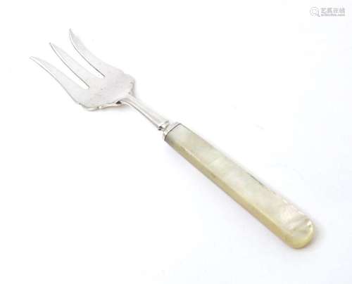 A silver three tine bread fork with a mother of pearl handle...