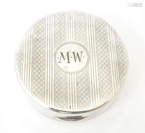 A silver Art Deco pill box of circular form with engine turn...