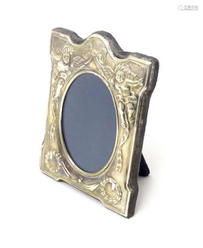 An easel back photograph frame with embossed silver surround...