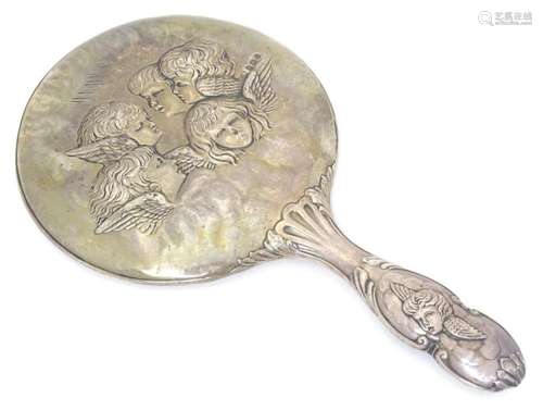 A silver backed hand mirror with embossed angle / cherub dec...