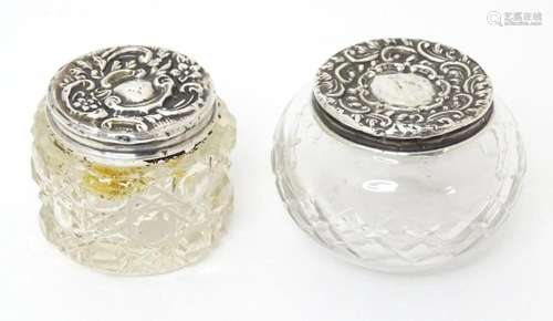 Two cut glass dressing table pots with embossed silver lids,...