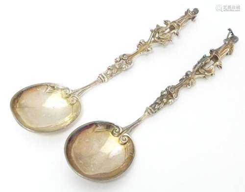 An unusual pair of silver plate spoons the cast handles with...