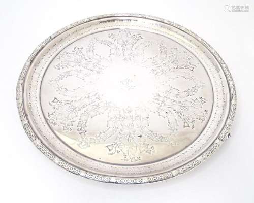 A silver plate salver with engraved decoration. 12" dia...