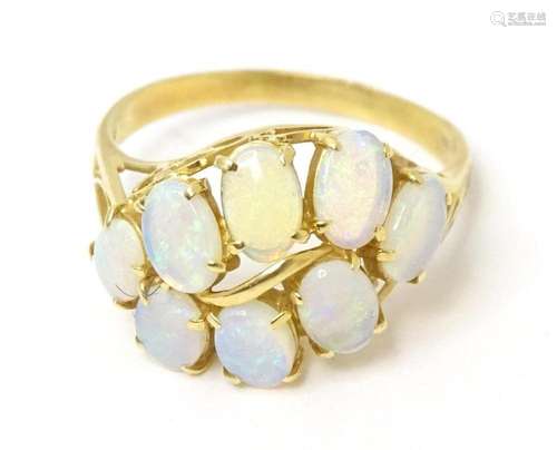 An 18ct gold ring set with eight opals. Ring size approx Q