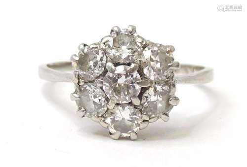 A platinum and diamond ring set with 7 diamonds in a daisy s...