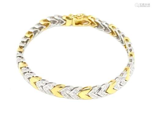 An 18ct white and yellow gold bracelet with diamonds in a ch...