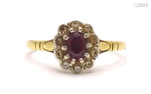 An 18ct gold ring set with a central ruby bordered diamonds....