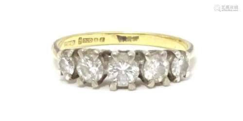 An 18ct gold ring set with five diamonds in a linear setting...