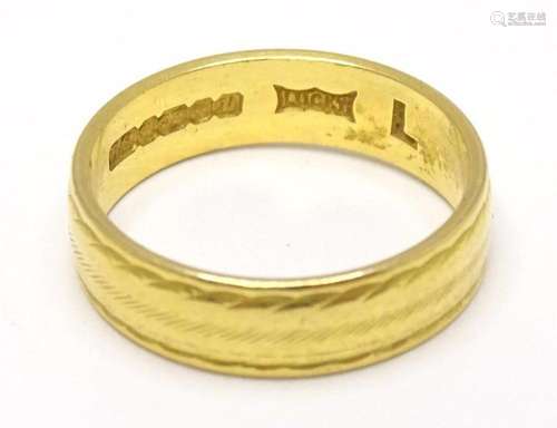 A 22ct gold band. Ring size approx. K 1/2