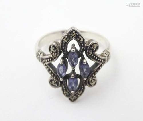 A silver dress ring set with amethysts and marcasite detail....